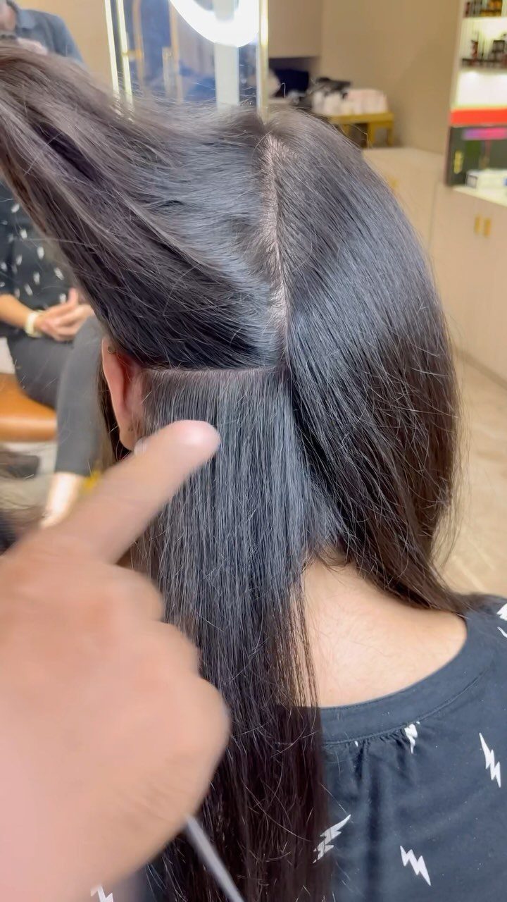 Root Touch Up Hair Colour: 3 Ideas for Fresh Roots 1 Dark hair being sectioned horizontally by a hand in a salon setting.