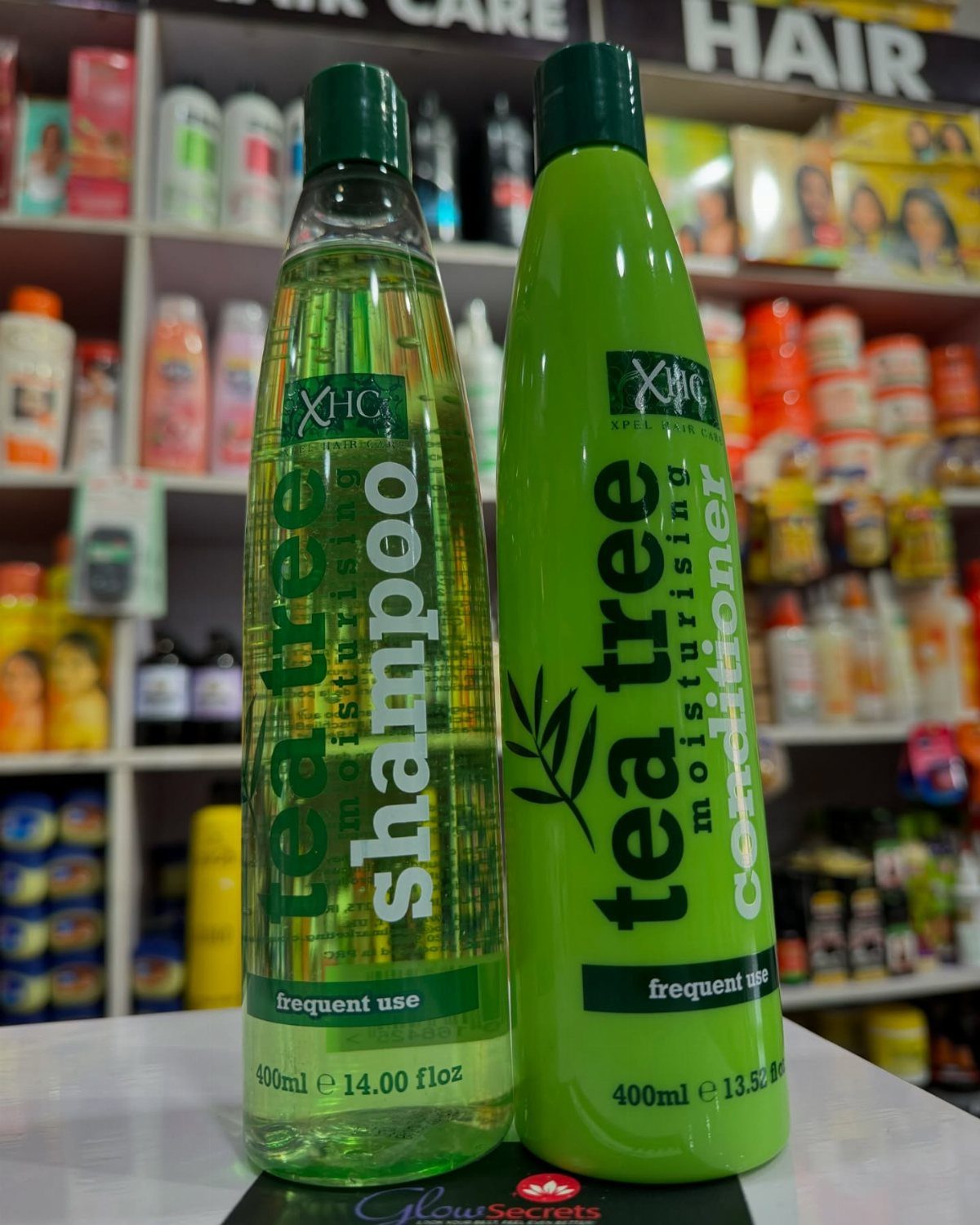 Scalp Care for Dandruff: 3 Ideas to Try at Home 2 Tea tree shampoo and conditioner bottles standing in front of beauty store shelves.