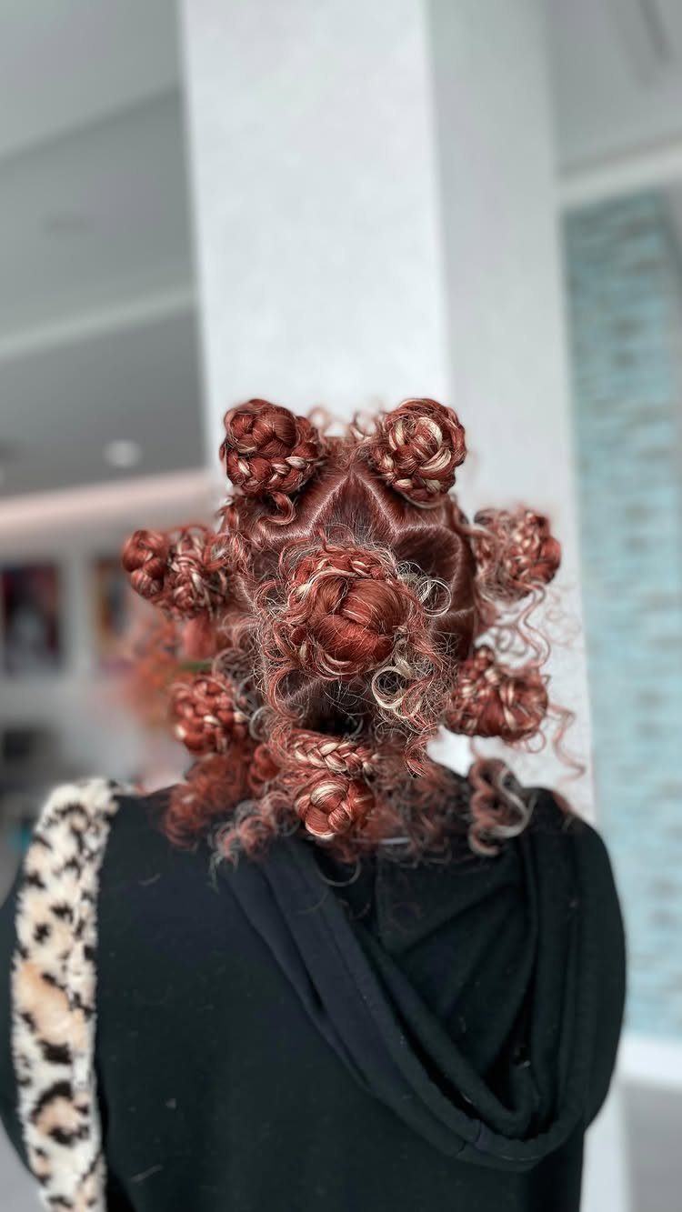 21 Short Curly Hair Styling Ideas for Every Texture 15 Reddish-brown hair styled into several small, coiled Bantu knots from the back.
