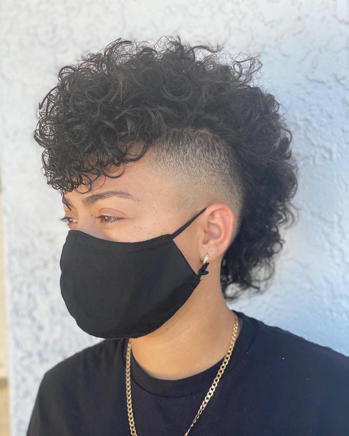 21 Short Curly Hair Styling Ideas for Every Texture 7 Person with a curly mohawk hairstyle, shaved sides, and a black face mask.