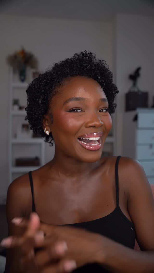 21 Short Curly Hair Styling Ideas for Every Texture 11 Woman with short, tight black curly hair smiling in a black top.