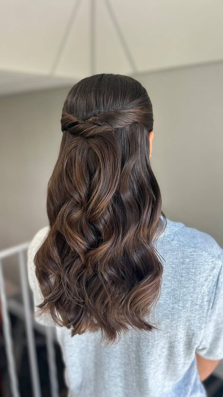 10 Sleek Hair Styles for Every Length and Occasion 3 Long wavy brown hair styled in a sleek half-up, half-down twisted look.