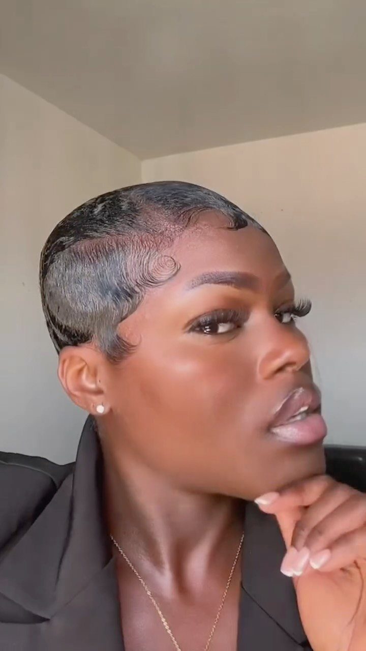 10 Sleek Hair Styles for Every Length and Occasion 8 Woman with a sleek, slicked-back pixie cut and styled edges wearing a black blazer.