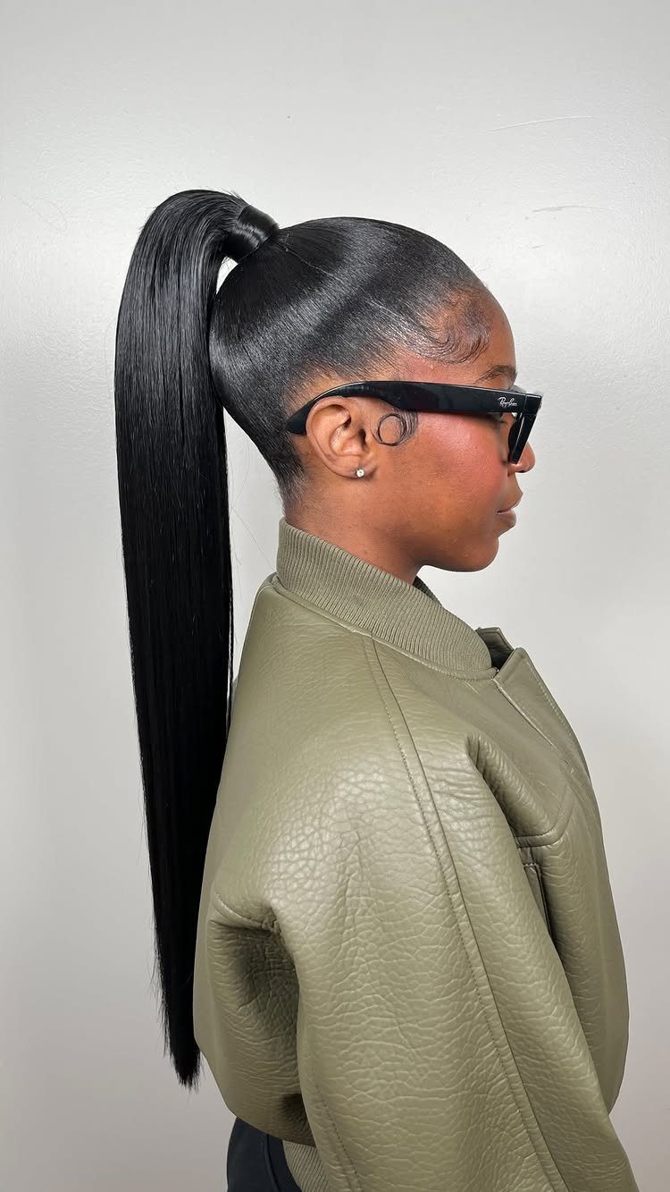 5 Sleek High Pony Ideas with Braids, Curls and Edges 3 Woman with a polished slicked-back high ponytail wearing an olive green leather jacket.
