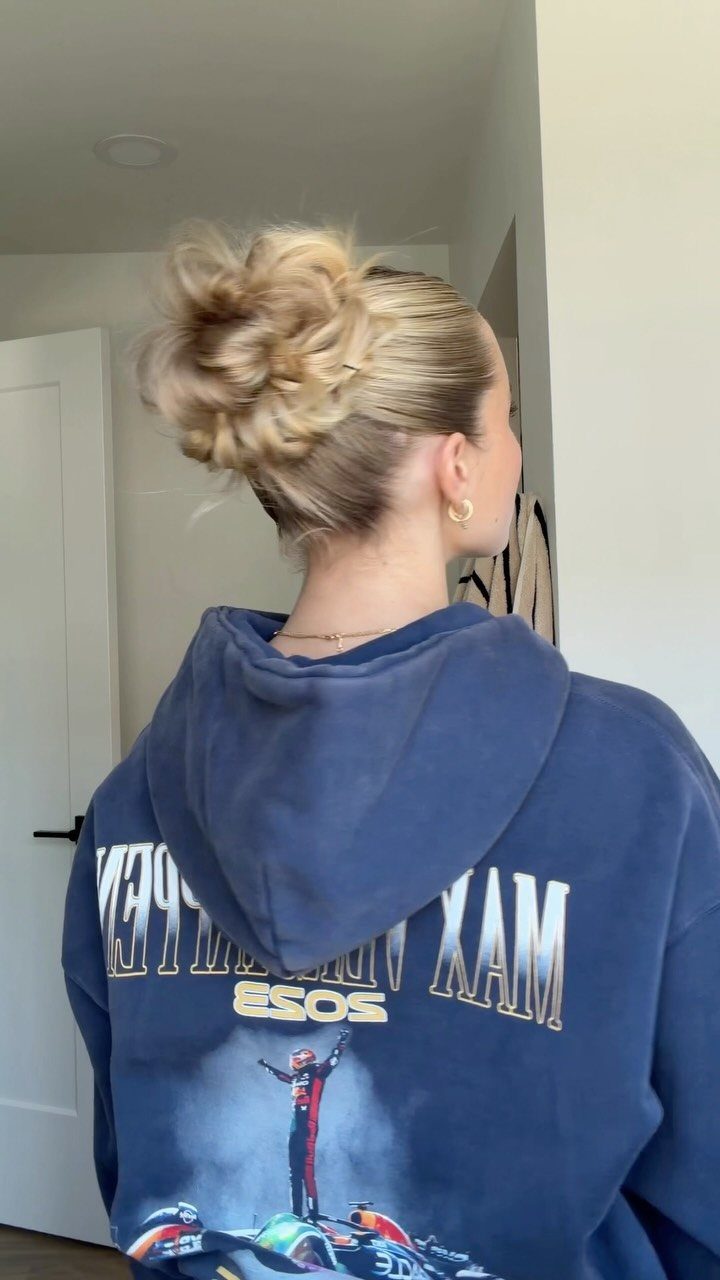 Slickback Messy Bun Ideas: 5 Easy Styles to Try 4 Woman with blonde hair styled in a slicked-back messy bun wearing a blue hoodie.