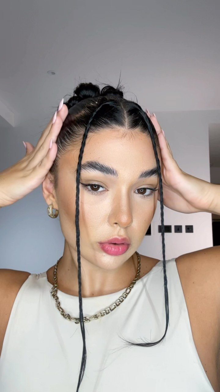 Slickback Messy Bun Ideas: 5 Easy Styles to Try 5 Woman with a slicked-back high bun and two thin braids framing her face.