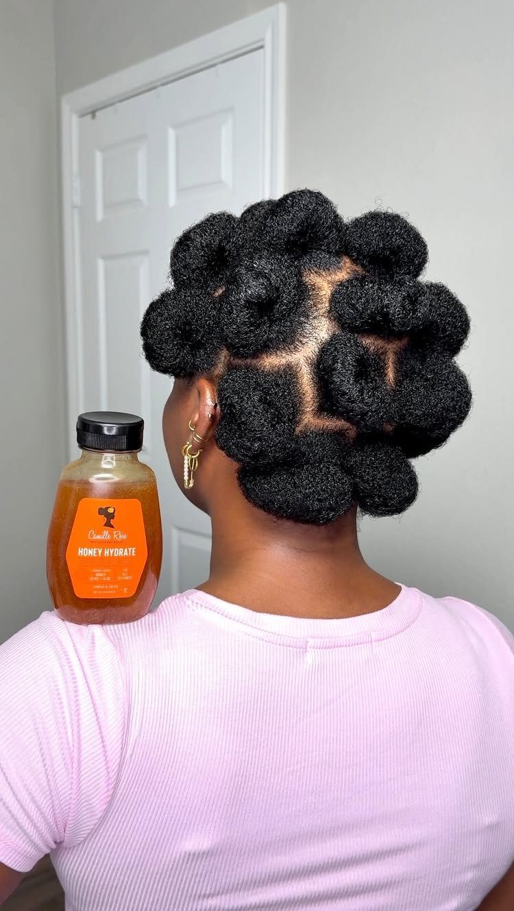 20 Thick Natural Hairstyles for Every Length and Mood 3 Woman with black natural hair styled in coiled Bantu knots wearing purple shirt