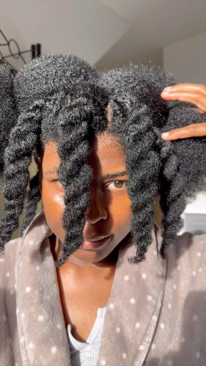 20 Thick Natural Hairstyles for Every Length and Mood 19 Woman with thick natural hair styled in chunky twisted coils wearing a robe