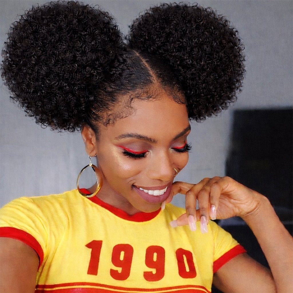 20 Thick Natural Hairstyles for Every Length and Mood 5 Woman with two large curly hair puffs wearing a yellow 1990 t-shirt.