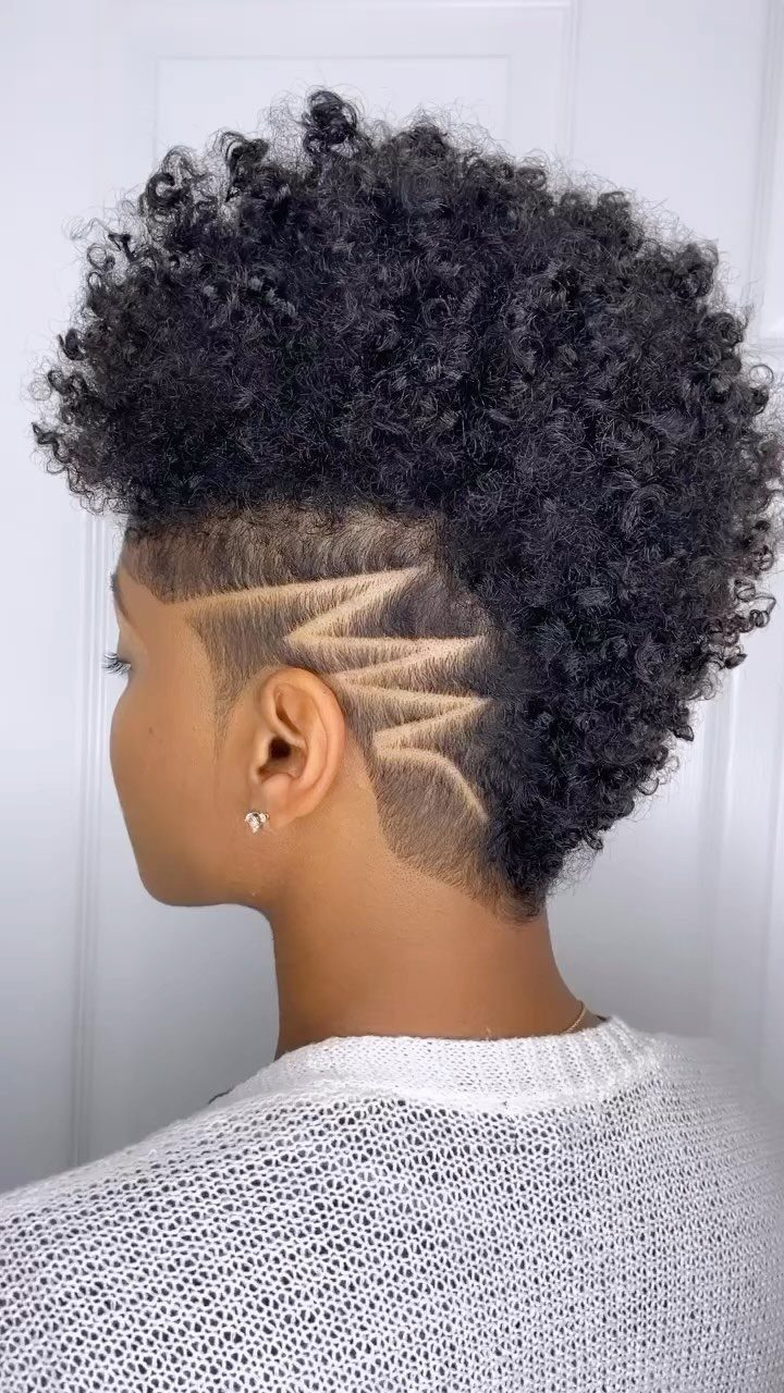 20 Thick Natural Hairstyles for Every Length and Mood 8 Woman with a curly mohawk hairstyle and geometric shaved designs on the sides.
