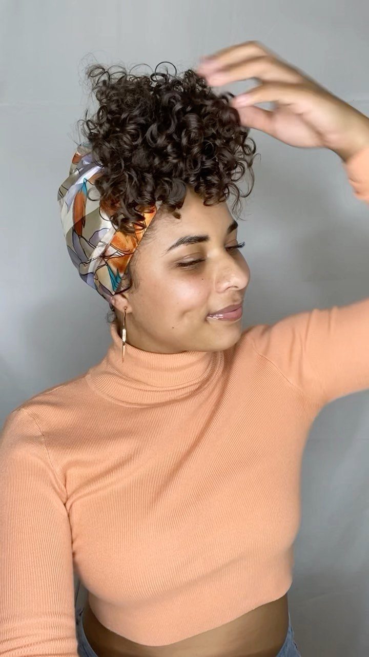 20 Thick Natural Hairstyles for Every Length and Mood 6 Woman with curly brown hair styled in a pineapple updo and colorful headscarf.