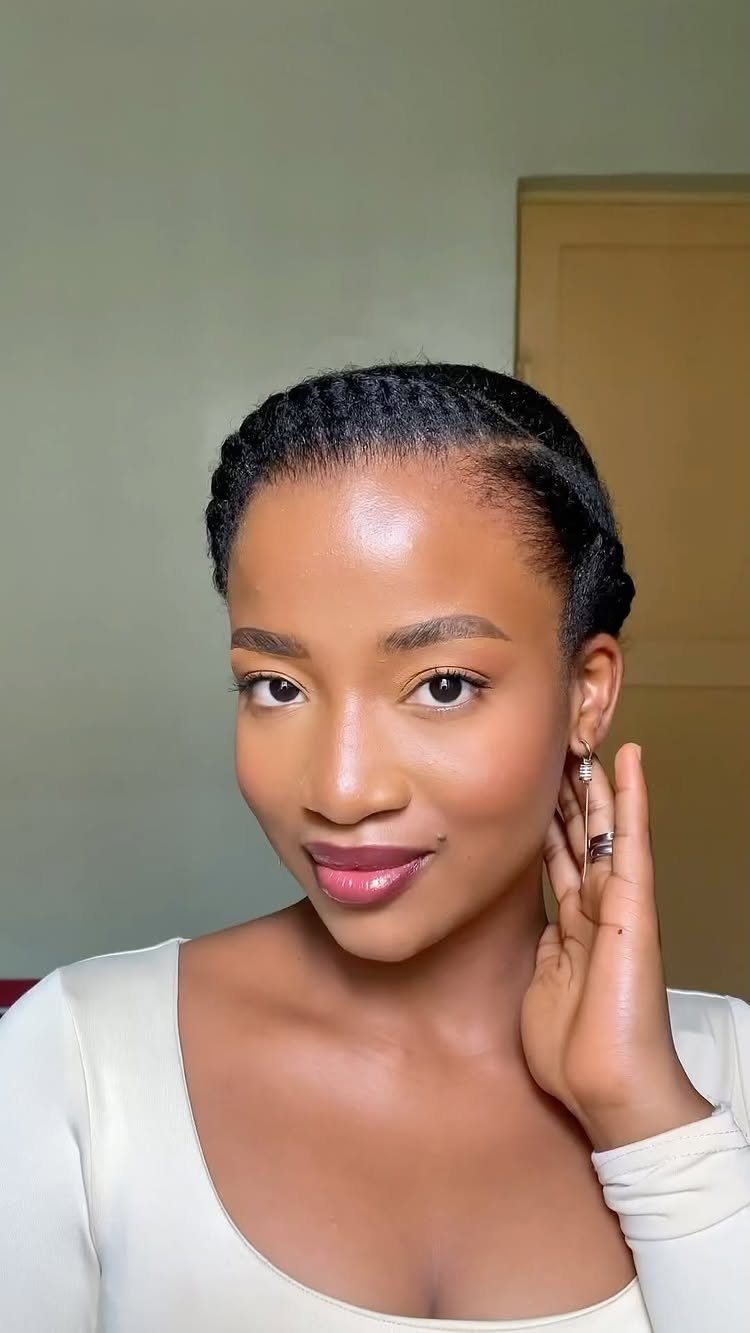 20 Thick Natural Hairstyles for Every Length and Mood 9 Woman with black hair styled in cornrows wearing a white top.