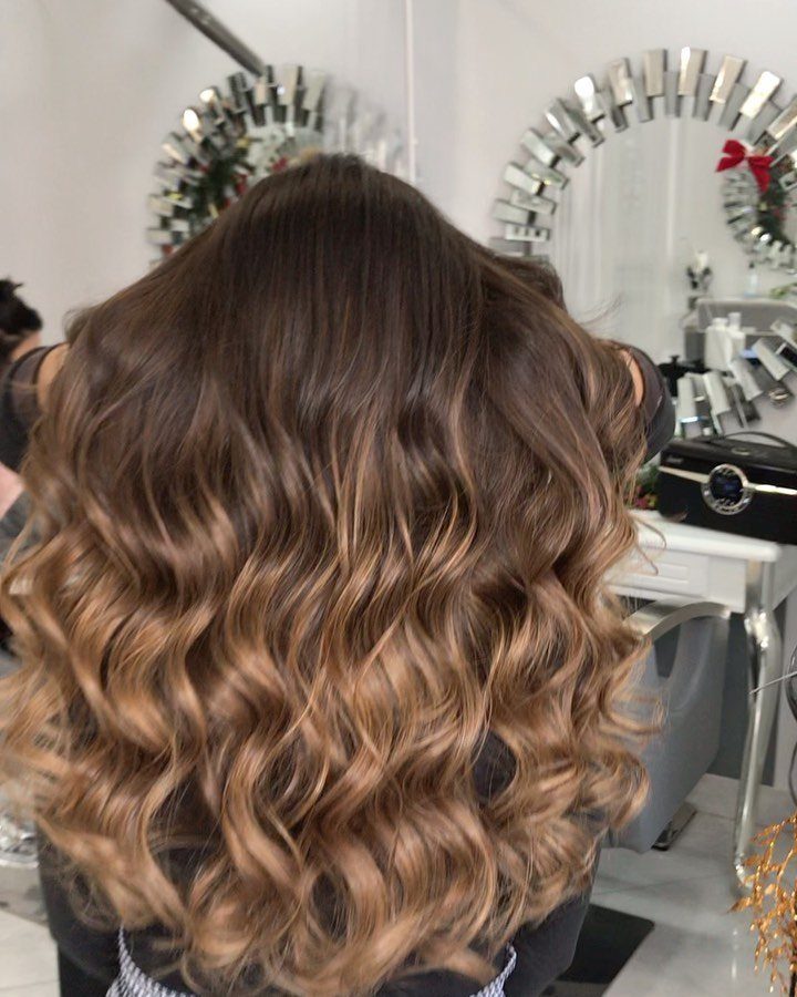 9 Toffee Caramel Hair Ideas for Brown and Blonde Bases 9 Long wavy hair with dark roots and golden toffee caramel highlights in salon