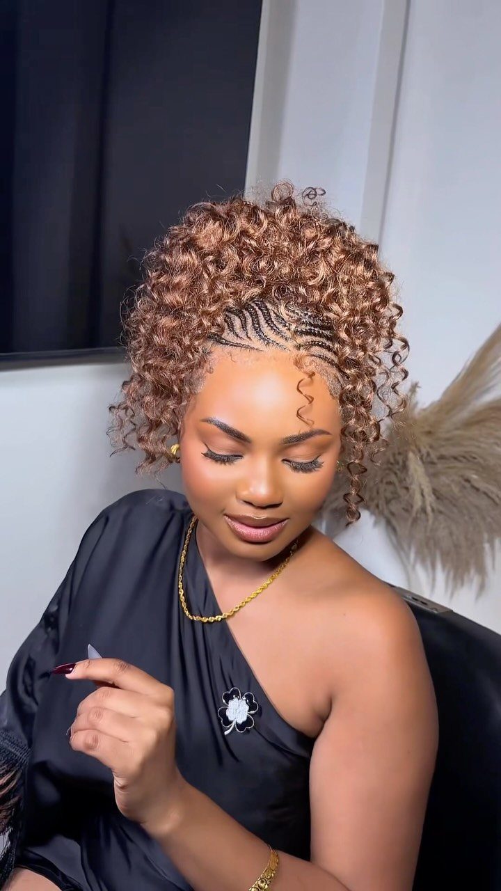 27 Trending Black Hairstyles, from Microbraids to Sisterlocks 6 Woman with a curly brown mohawk hairstyle and braided sides wearing black clothing.