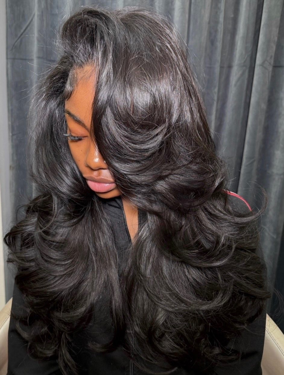 27 Trending Black Hairstyles, from Microbraids to Sisterlocks 23 Woman with long, voluminous black hair styled in layered, bouncy curls.