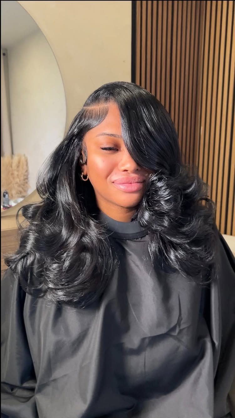 27 Trending Black Hairstyles, from Microbraids to Sisterlocks 16 Woman with long, voluminous black curly hair and a deep side part.