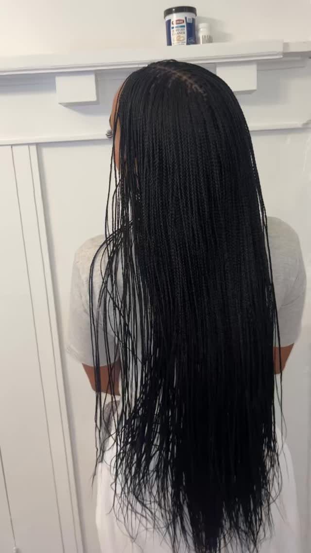 27 Trending Black Hairstyles, from Microbraids to Sisterlocks 1 Long black microbraids flowing down the back of a person in a white shirt.
