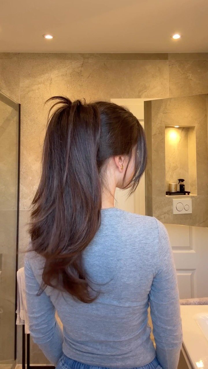 13 Trending Hair Style Ideas, from Curtain Bangs to Pixies 8 Woman with long brown hair styled in a high, voluminous ponytail from behind.