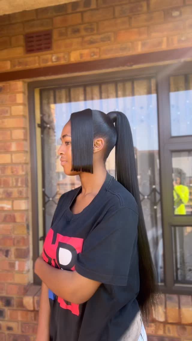 13 Trending Hair Style Ideas, from Curtain Bangs to Pixies 6 Woman with a sleek high ponytail and blunt bangs standing by a brick wall