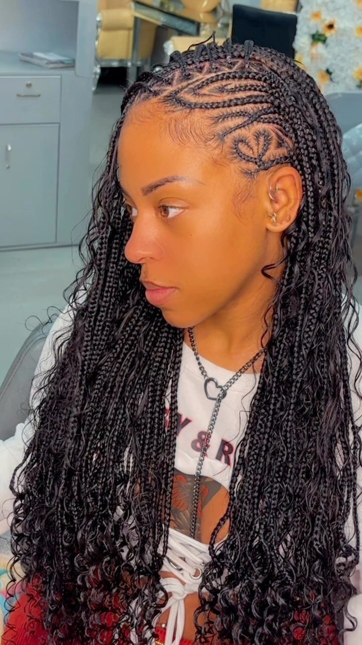 19 Tribal Braids with Boho Ideas, From Bobs to Buns 8 Woman with black bohemian braids and heart-shaped stitch braids on the side.