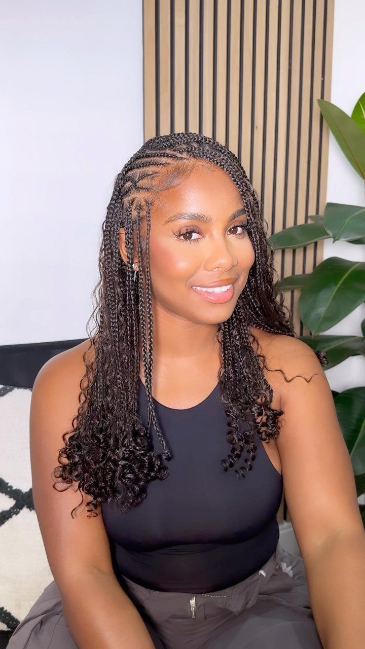 19 Tribal Braids with Boho Ideas, From Bobs to Buns 5 Woman with long black bohemian braids and cornrows wearing a black top.