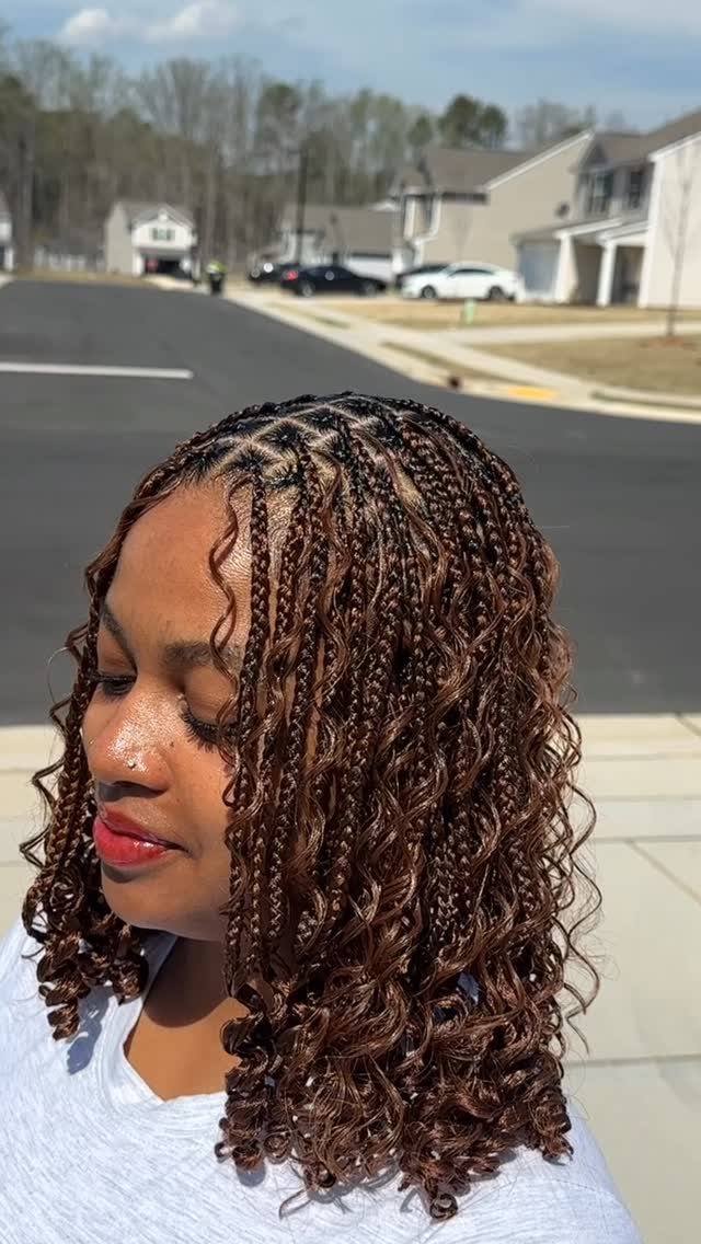 19 Tribal Braids with Boho Ideas, From Bobs to Buns 9 Woman with small brown boho braids and curly ends posing outdoors in sunlight.