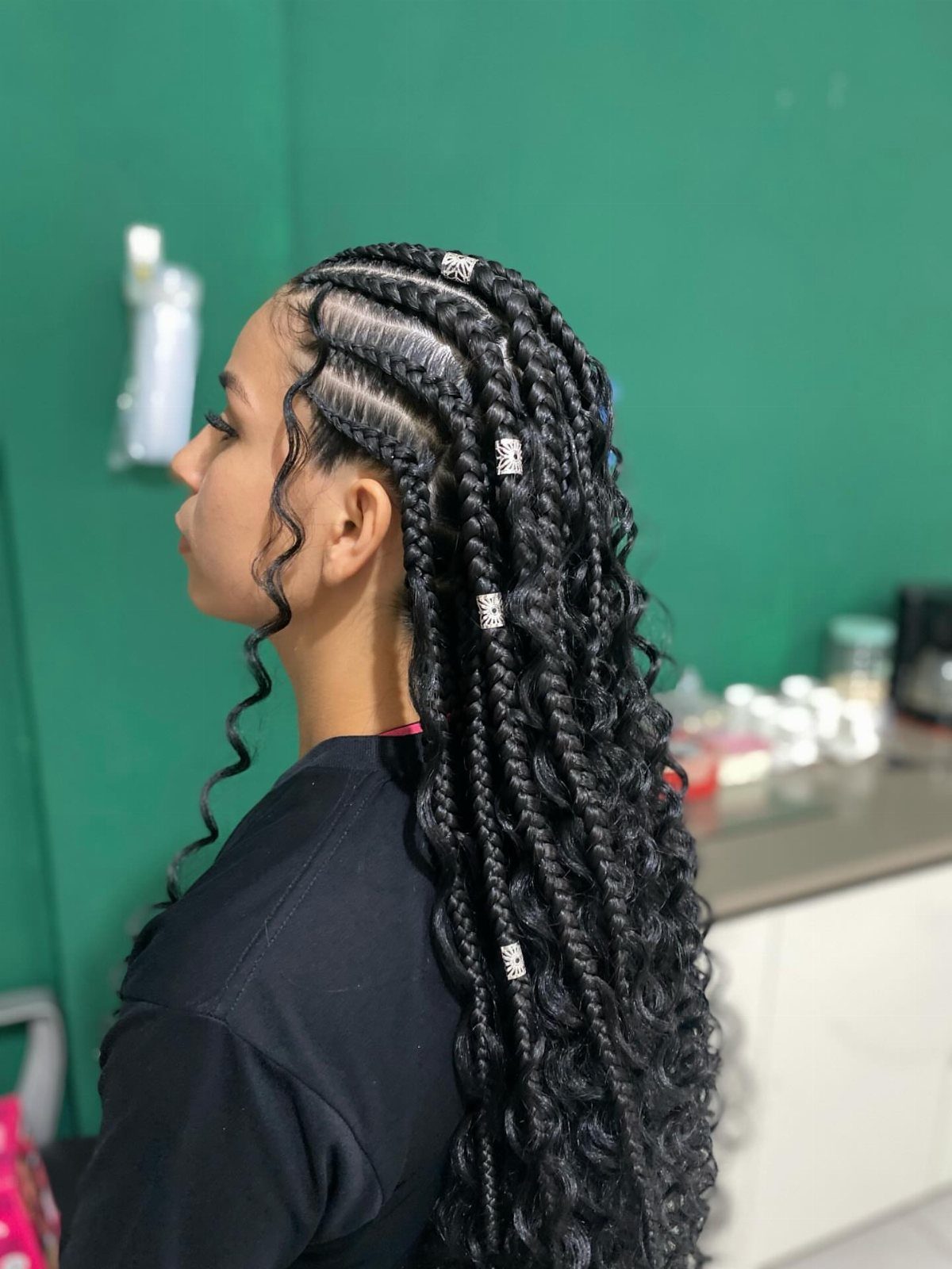 19 Tribal Braids with Boho Ideas, From Bobs to Buns 15 Woman with long black tribal braids featuring curly boho ends and silver cuffs.