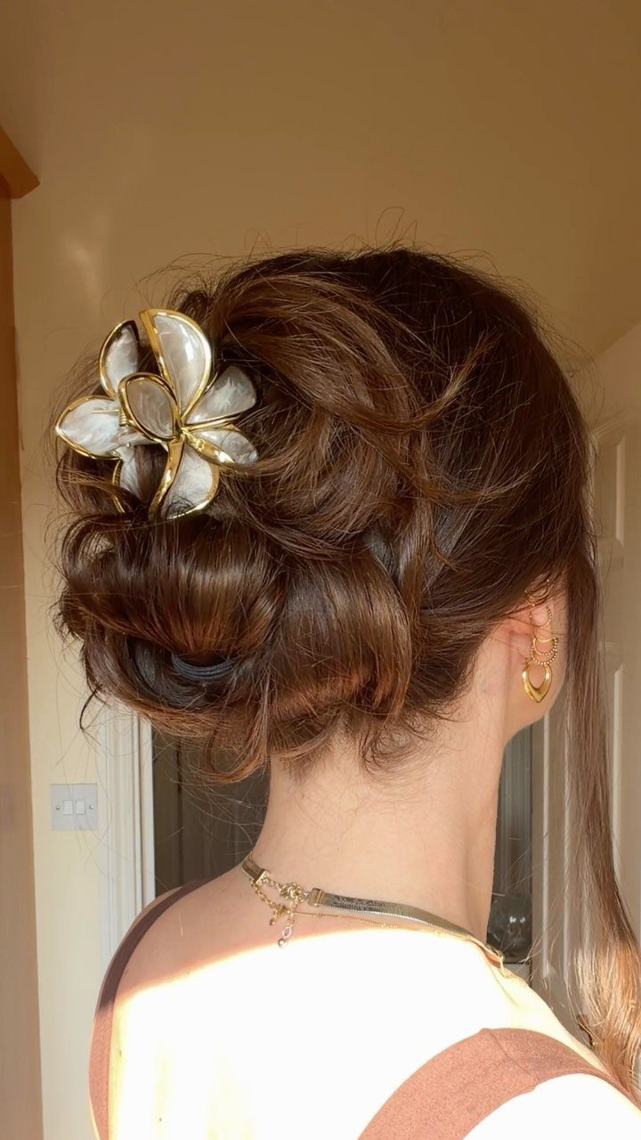 11 Updo Hairstyles for Casual Days and Easy Weekends 5 Brown hair styled in a textured updo secured with a gold flower clip.