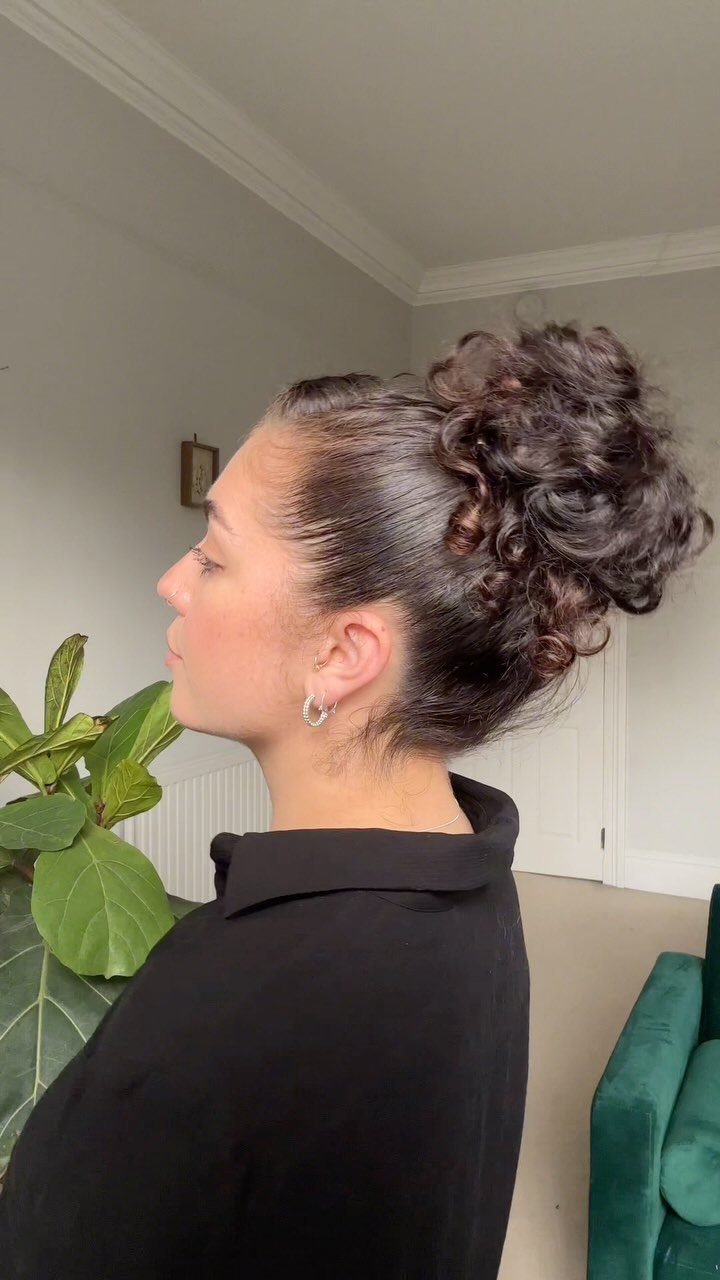 11 Updo Hairstyles for Casual Days and Easy Weekends 1 Woman with dark brown hair styled in a high, voluminous curly updo.