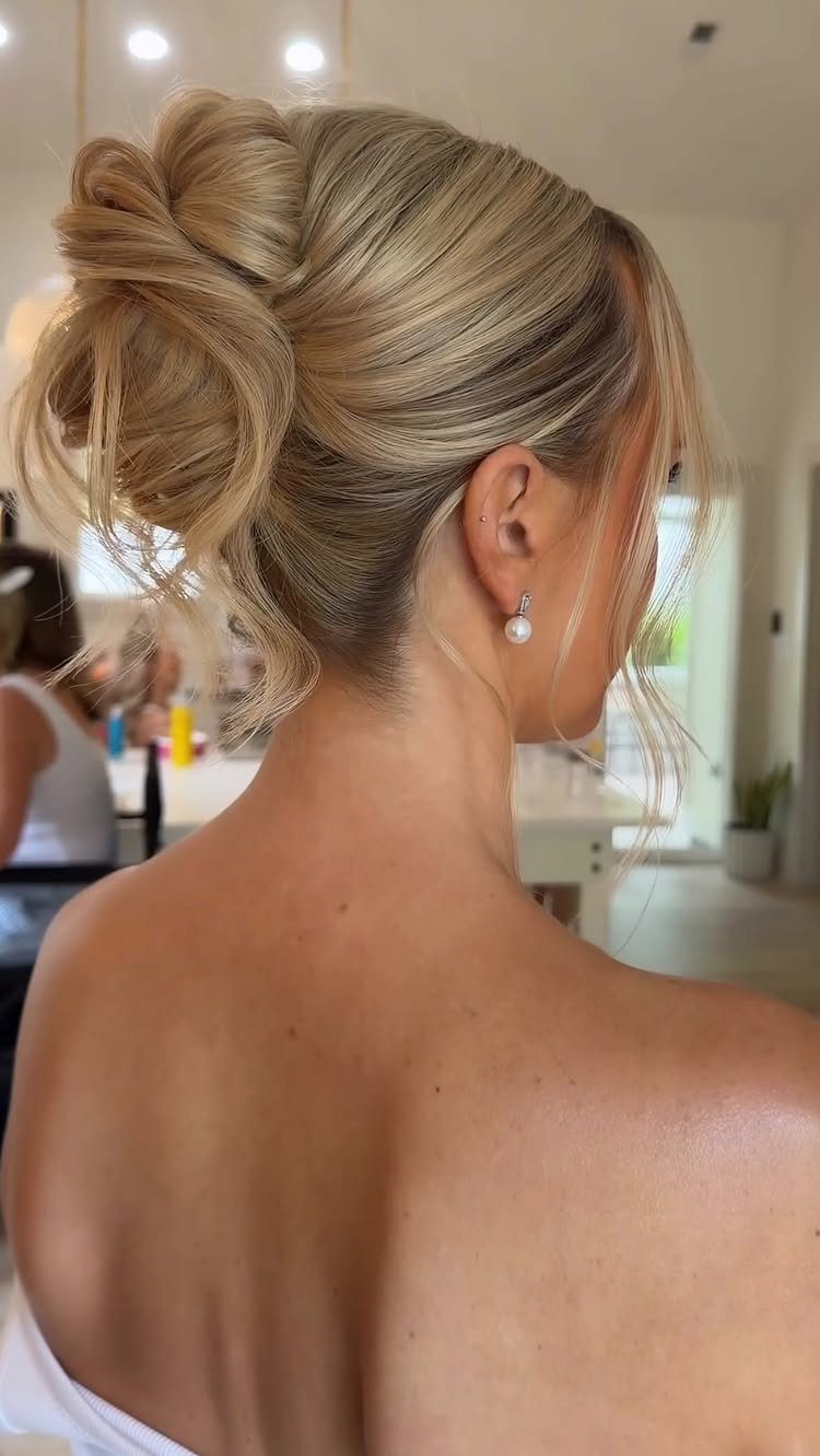 11 Updo Hairstyles for Casual Days and Easy Weekends 11 Blonde woman with a loose, textured updo bun and a pearl earring.