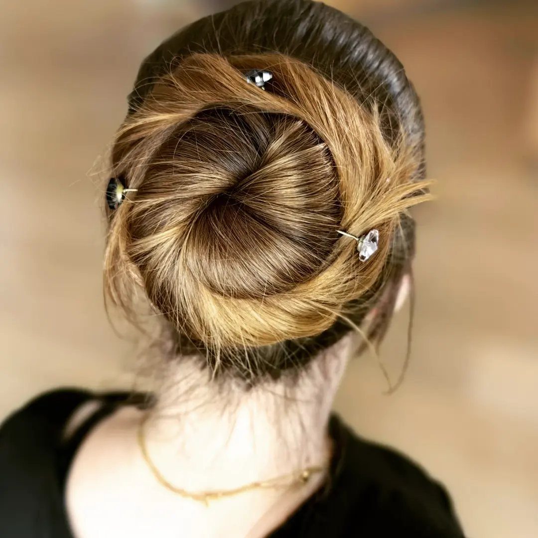 11 Updo Hairstyles for Casual Days and Easy Weekends 4 Twisted brown and blonde hair bun adorned with three sparkling jeweled hairpins.