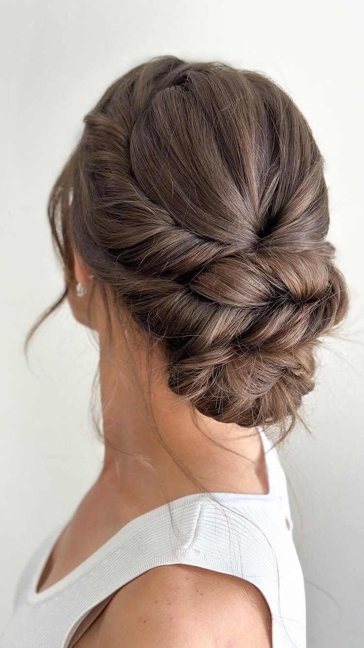 11 Updo Hairstyles for Casual Days and Easy Weekends 7 Brown hair styled in a textured updo with twists and a low bun.