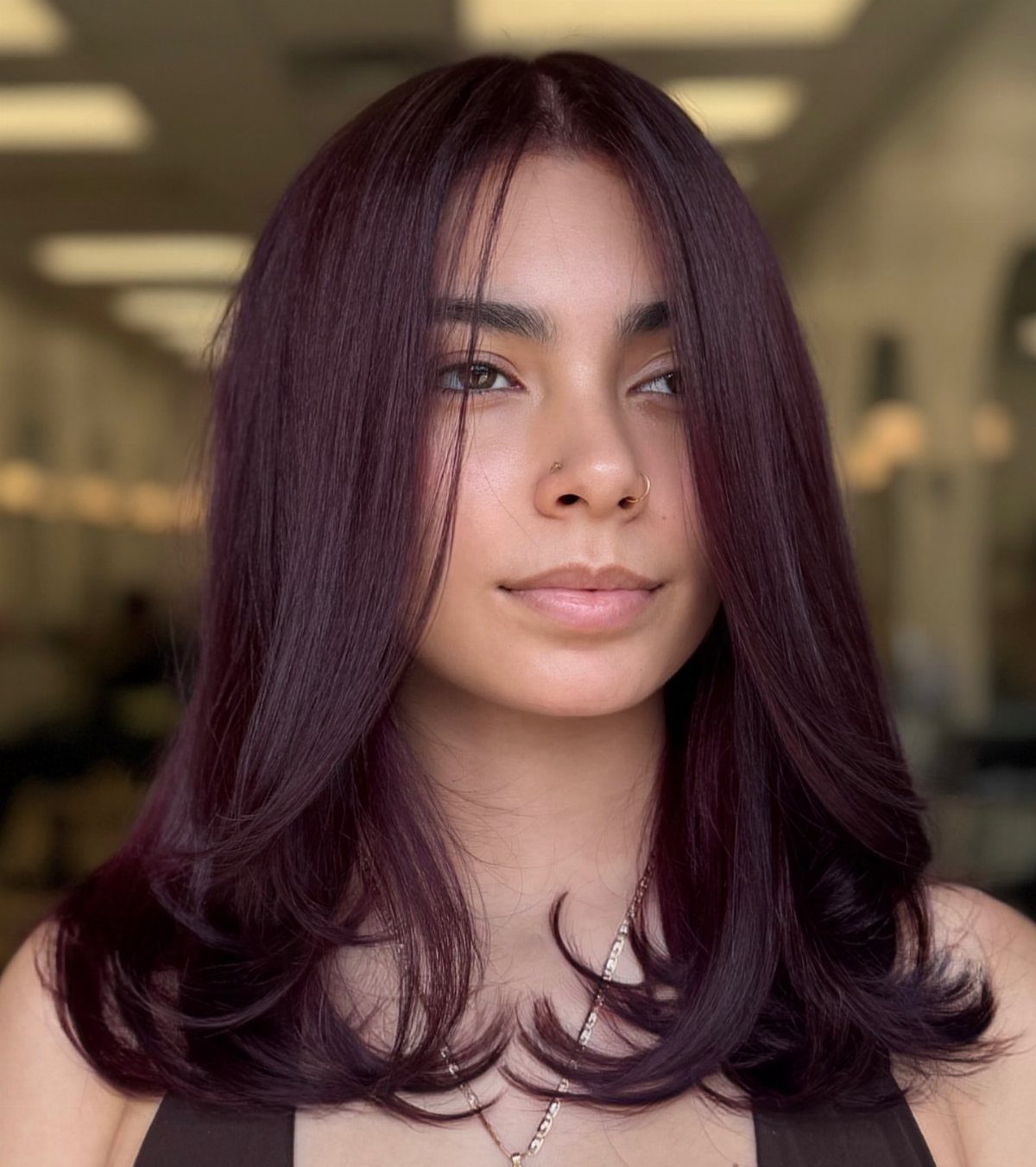 10 Violet Burgundy Hair Ideas for Dark to Bright Looks 6 Woman with sleek, bright burgundy blowout hair curled at the ends.