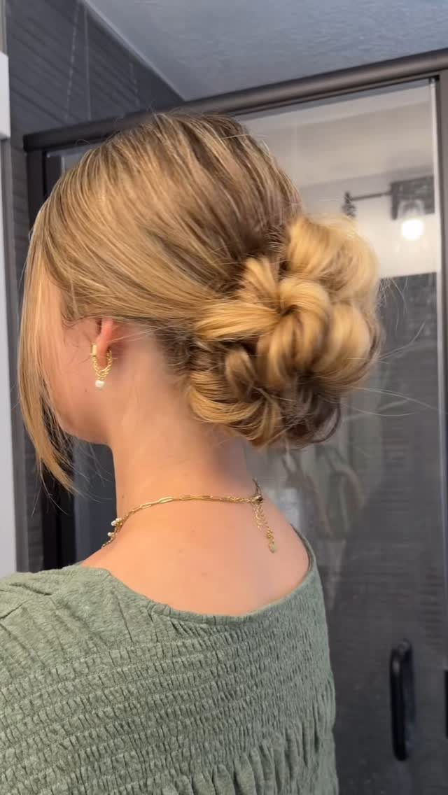 11 Wedding Guest Hairstyles for Medium Hair: Buns and Braids 3 Blonde woman with a textured messy bun hairstyle and gold jewelry.
