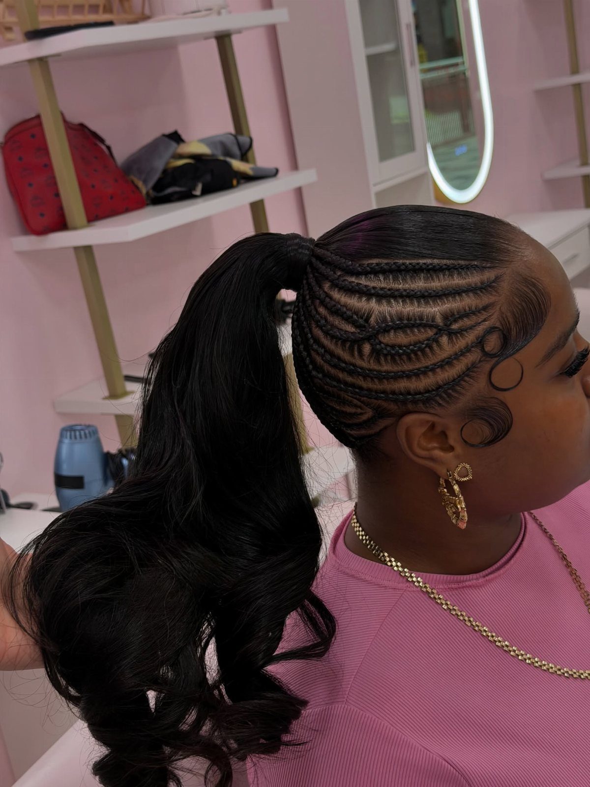 Y2K Braid Hairstyles: 9 Ideas From Butterfly Clips to Cornrows 6 Woman with a high ponytail and intricate cornrow braids on the sides.