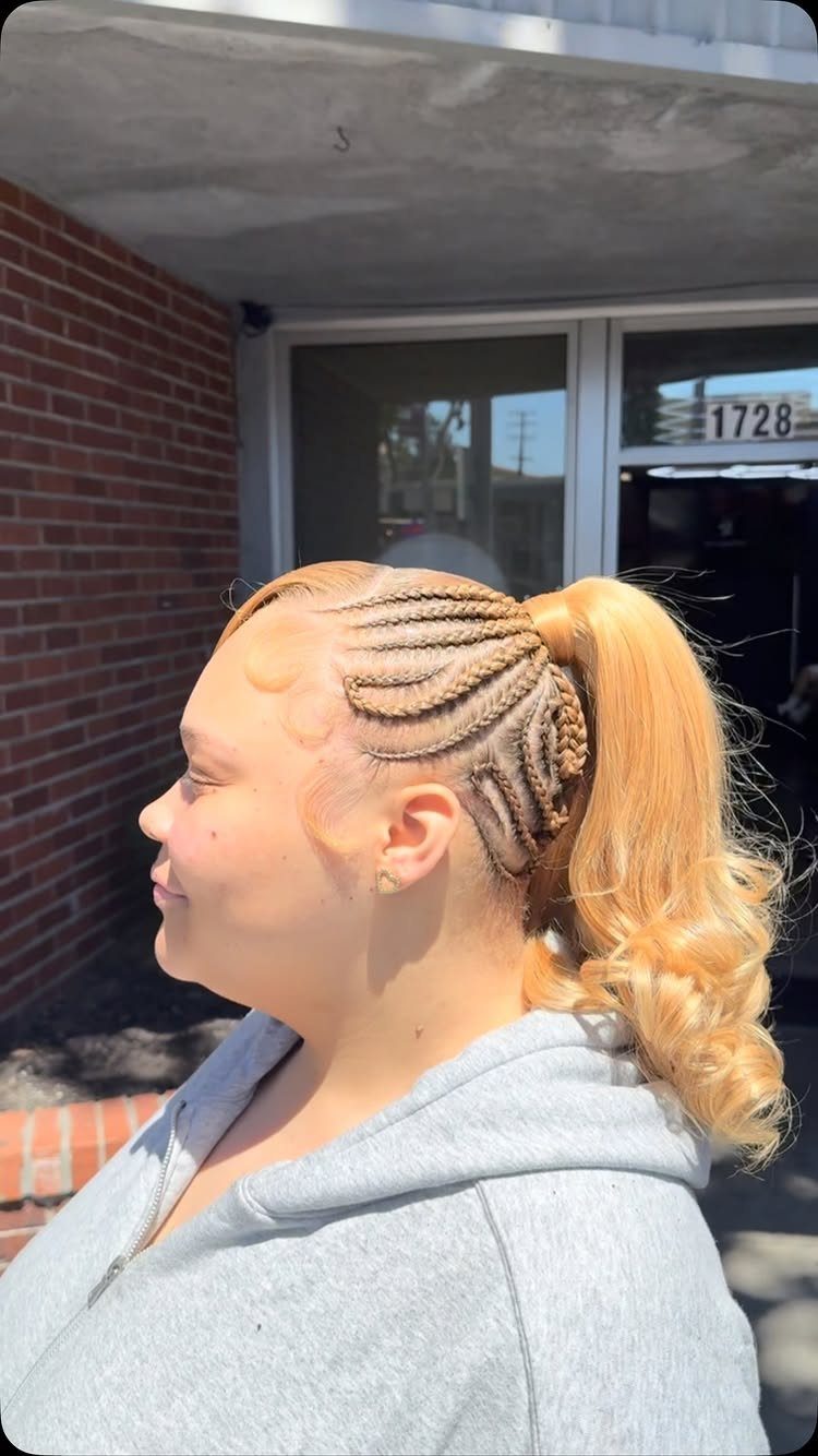 Y2K Braid Hairstyles: 9 Ideas From Butterfly Clips to Cornrows 3 Person with blonde cornrow braids tied into a high curly ponytail