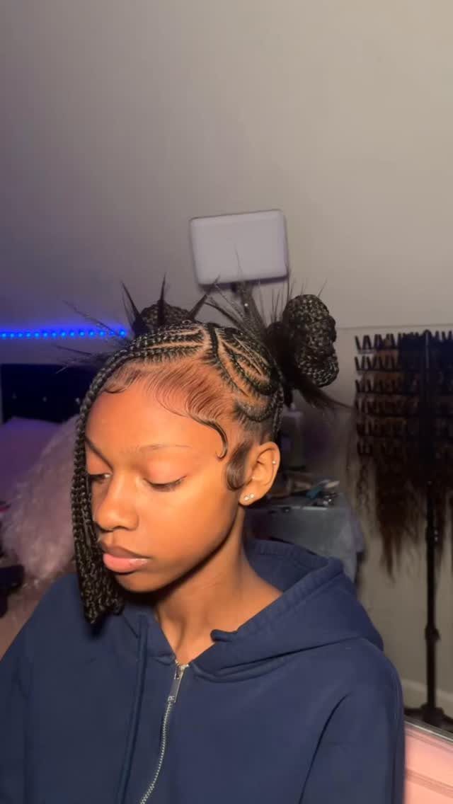 Y2K Braid Hairstyles: 9 Ideas From Butterfly Clips to Cornrows 2 Woman with cornrow braids and a spiky bun wearing a navy blue hoodie.